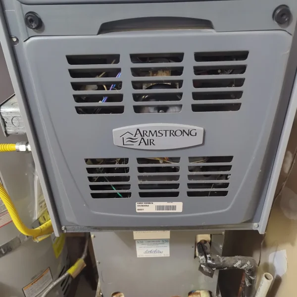 Armstrong Air furnace with the service panel and gas line visible