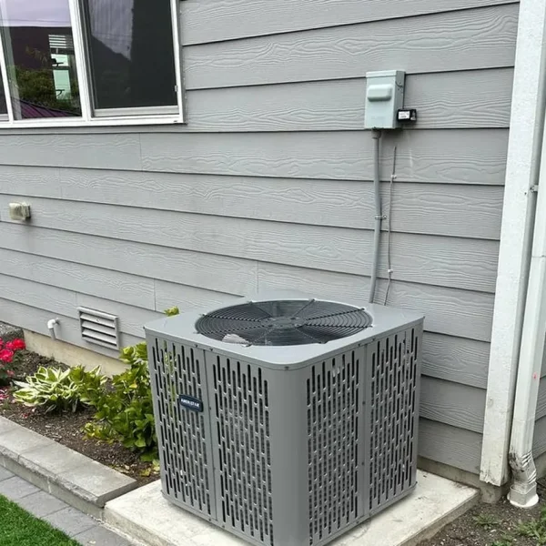 Central air conditioner installed on a pad beside a lawn