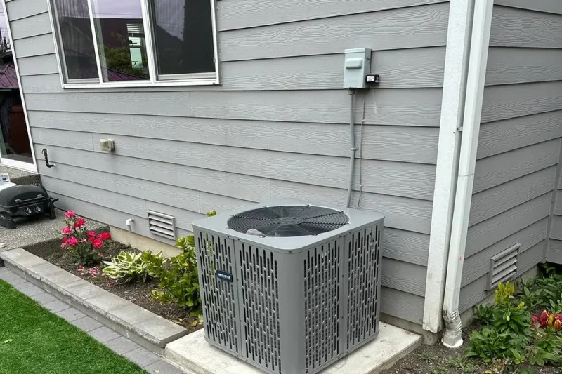 Central air conditioner installed on a pad beside a lawn