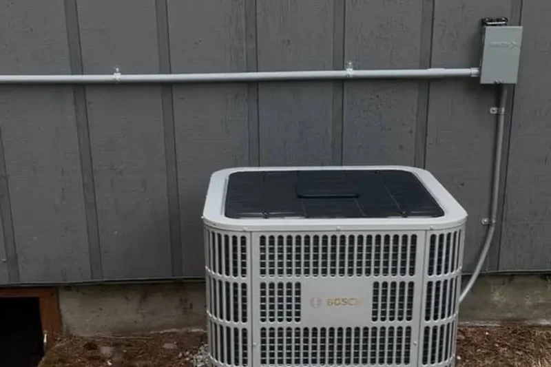 Central air conditioner installed against a grey wall