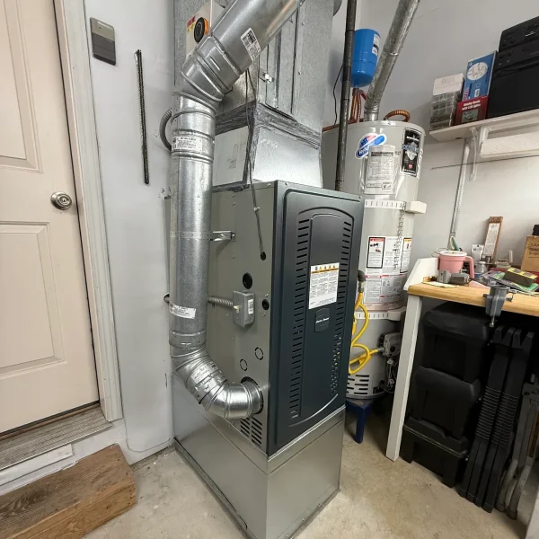 Furnace and new ducting in a garage next to the water heater