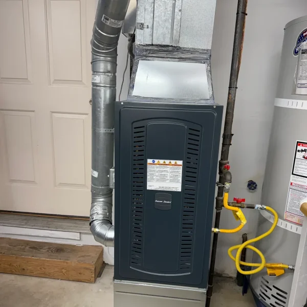 Furnace installed in a garage beside a water heater