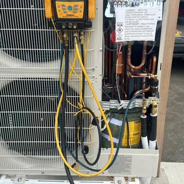 Heat pump opened for diagnostics with service gauges connected