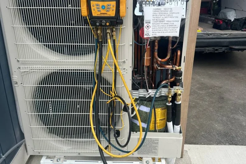 Heat pump opened for diagnostics with service gauges connected