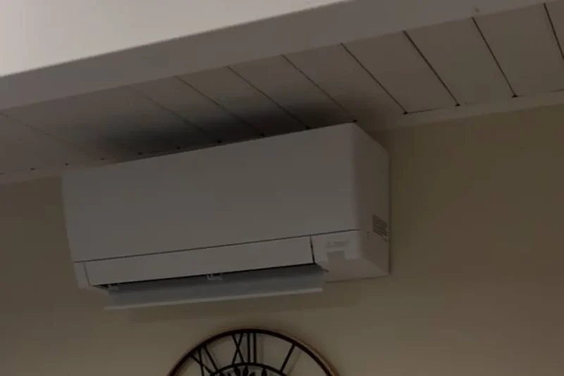Ductless mini-split indoor head mounted above a wall clock