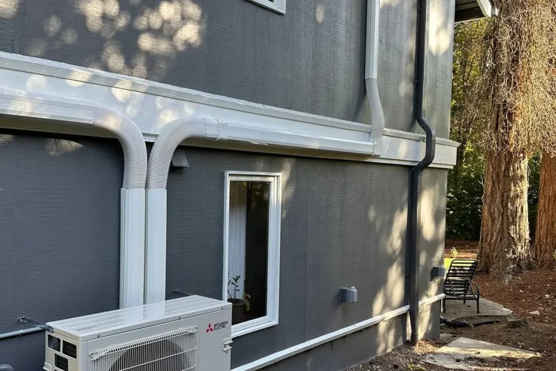 Mini-split outdoor unit installed against dark siding