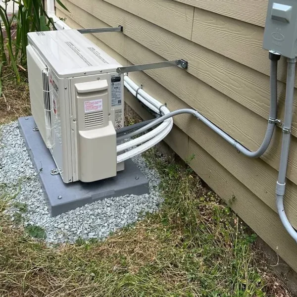 Mini-split outdoor unit with disconnect box and conduit run along the wall
