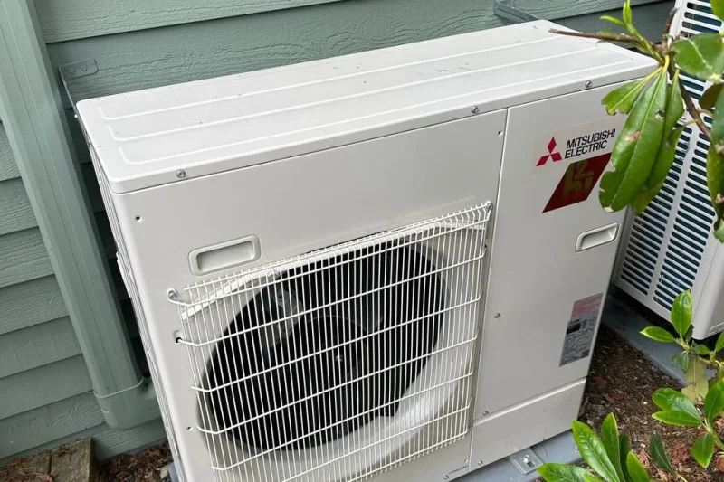 Mitsubishi outdoor unit installed against sage siding