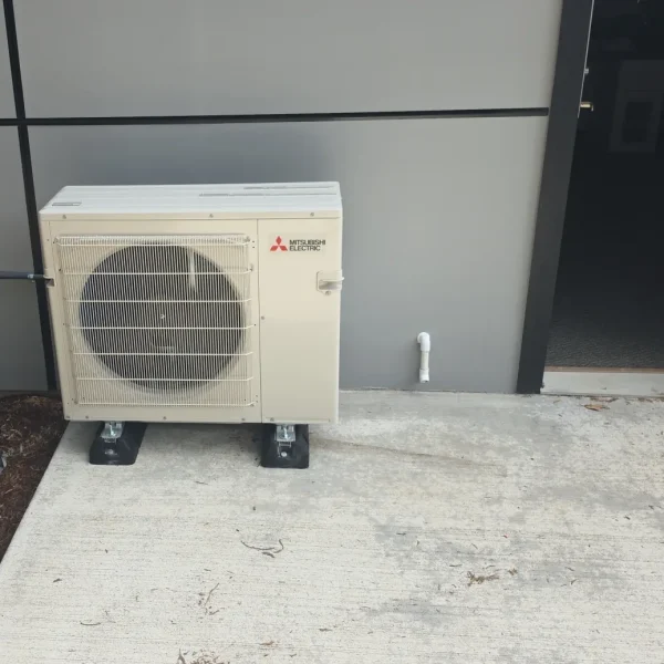 Mitsubishi outdoor unit standing on levelling feet on a concrete pad