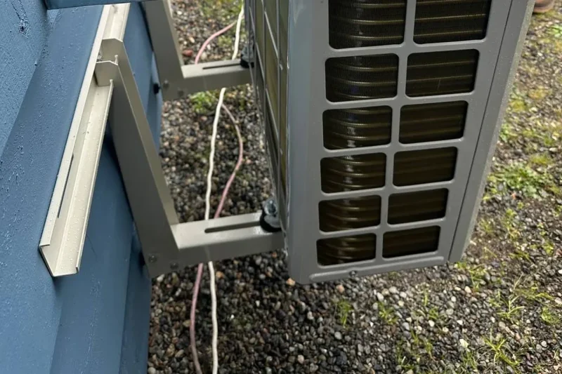 Outdoor unit being set on a wall bracket during installation