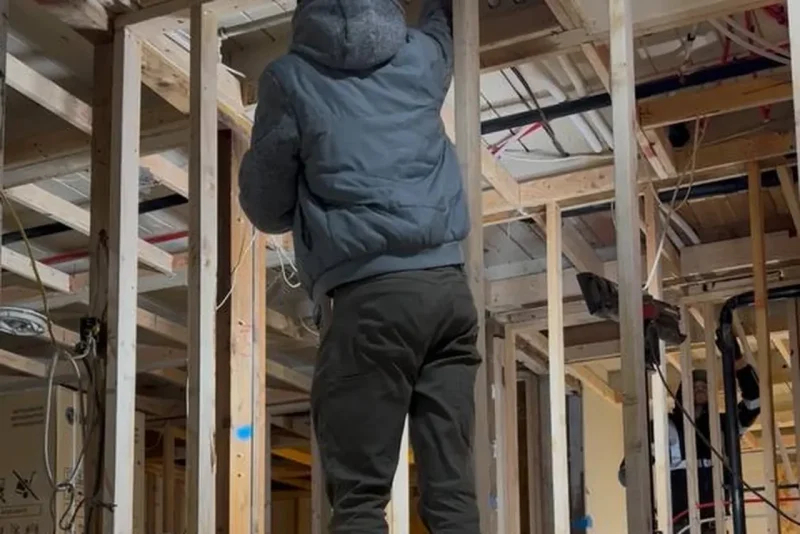 EverHeat technician working inside framing during a rough-in