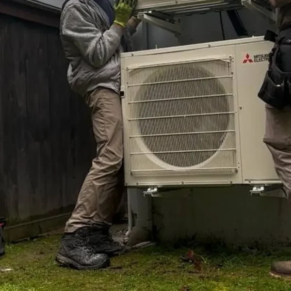 Two EverHeat technicians setting an outdoor unit in place